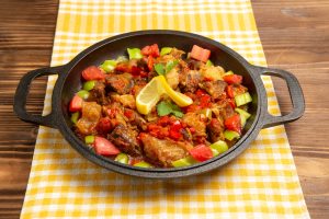 front-view-cooked-vegetable-meal-with-meat-sliced-bell-peppers-brown-desk